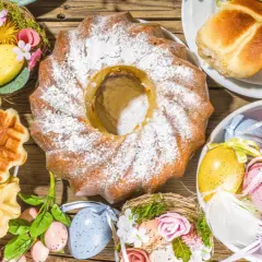 Kiedy jest śniadanie wielkanocne: babka, gofry, jajka w koszyczkach i bułeczki na drewnianym stole.