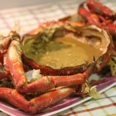 Centolla cocida con sus huevas, lista para disfrutar. Sus patas rojas y su caparazón lleno de sabor la hacen irresistible.