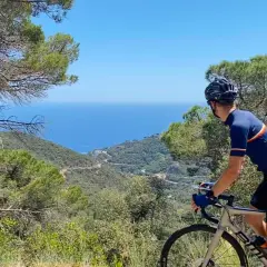 Cyclist enjoys a scenic ride, taking in breathtaking coastal views. This could be one of the best cycling routes in Europe.