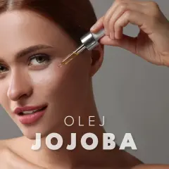 Kobieta aplikuje kroplę olejku jojoba na twarz, by nadać jej blask.