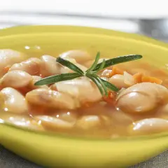 Zupa fasolowa przepis babci. Aromatyczna, sycąca, z dodatkiem rozmarynu, w żółtej miseczce.