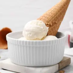Schüssel mit cremigem Joghurteis, dazu Waffelhörnchen. Perfekt zum Joghurteis selber machen.