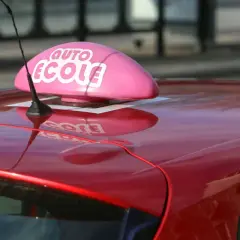 Voiture rouge d'auto-école, prête pour un jeune conducteur responsable qui vise le permis à 17 ans.