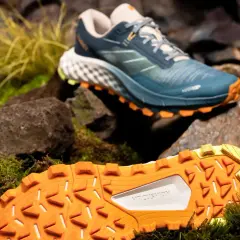 Buty trailowe co to? Zobacz te niebieskie buty z pomarańczową podeszwą, idealne na górskie wędrówki.