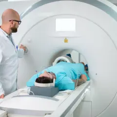 Lekarz przygotowuje pacjenta do badania rezonansem magnetycznym. Pacjent leży w aparacie, gotowy na test apleya.