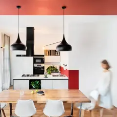 Soffitto rosso acceso per un tocco audace, un'idea pittura soffitto che valorizza la cucina moderna con lampade nere e arredi minimalisti.