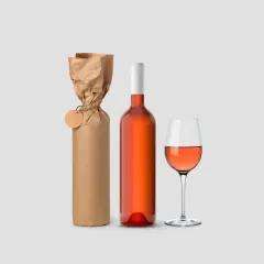 Eine Weinflasche verpacken: Eine Flasche Roséwein neben einer in braunes Papier eingewickelten Flasche mit Anhänger und einem Weinglas.