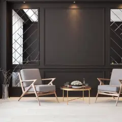 Elegancka czarna ściana w salonie aranżacje z dwoma szarymi fotelami i złotym stolikiem. Lustra w geometryczne wzory dodają głębi.