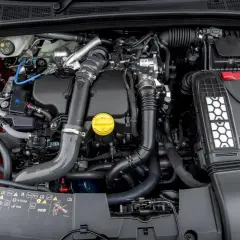 Silnik 1.5 dCi w samochodzie, z widocznymi elementami układu dolotowego i turbosprężarki.
