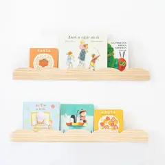 Dos estantes nube de madera con libros infantiles. En el superior: "Pasta", "Anem a caçar un ós" y "La pequeña oruga glotona". En el inferior: "En Tin a taula", un libro de pingüinos y "Fruta".