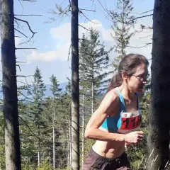 Anna Celińska biegnie przez las, numer 118 na piersi.