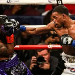 A boxer lands a powerful punch, while his opponent attempts to block with a jab. The intensity of the jab vs punch is palpable.