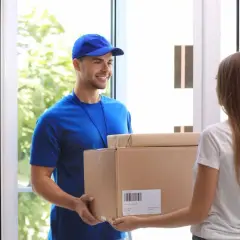 Lieferbote übergibt Frau ein Paket. Sie hofft, dass es nicht die **nicht bestellte Ware** ist, die sie schon einmal erhalten hat.