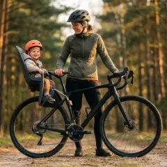 Szczęśliwe dziecko w foteliku rowerowym, gotowe na przygodę. Sprawdź nasz fotelik rowerowy ranking, by wybrać najlepszy model!