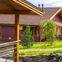 Drewniany domek z brązowym dachem i zielonym ogrodem.