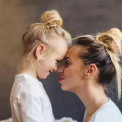 Blondynka z córką, dziecko z poprzedniego związku, czule dotykają się noskami. Nowy partner wkracza w ich życie.