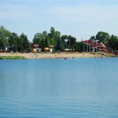 Letnia plaża z czerwonymi zjeżdżalniami wodnymi nad jeziorem, popularne miejsce wypoczynku, Morskie Oko Wrocław.