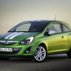 Zielony Opel Corsa D 1.2 benzyna z białymi pasami na masce, zaparkowany na plaży.