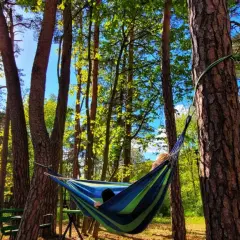 Relaks w hamaku w lesie. Słońce przebija się przez drzewa, tworząc magiczną atmosferę w ośrodku wypoczynkowym Świderek.