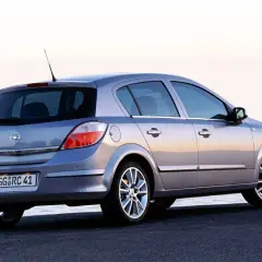 Srebrny Opel Astra H 1.6 benzyna z widokiem z tyłu, zaparkowany nad morzem.