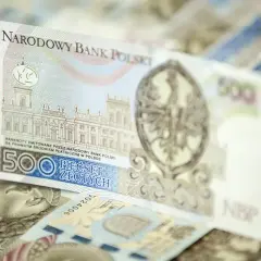 Stos banknotów 500 zł. Widoczny fragment z budynkiem i orłem.