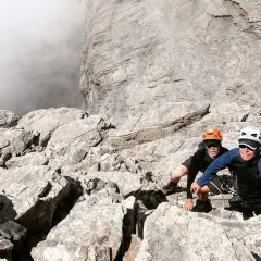 Dwóch wspinaczy na skalistym zboczu Olimpu w Grecji. Zwiedzanie górskich szlaków to przygoda!