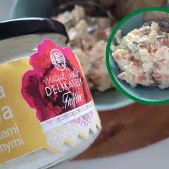 Słoik sałatki jarzynowej z marynowanymi grzybkami, inspirowanej przepisami Magdy Gessler. Obok miseczka pełna tej pysznej sałatki.