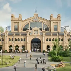 Tętniąca życiem hala Gwardii z ludźmi odpoczywającymi na trawie i przy stolikach kawiarnianych.