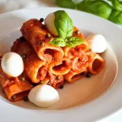 Rigatoni z aromatycznym, czerwonym pesto, kulkami mozzarelli i świeżą bazylią. Pyszne danie, które zachwyca smakiem.