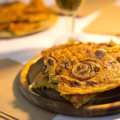 Farinata dorata, un classico per sapere cosa mangiare a Pisa. Croccante fuori, morbida dentro, con cipolle caramellate.