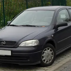 Ciemnoszary Opel Astra G 1.6 16v stoi na chodniku.