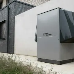 Une pompe à chaleur Alpha Innotec est installée près d'un bâtiment moderne. Elle fonctionne pour réguler la température, mais combien de temps tourne une pompe à chaleur par jour ?