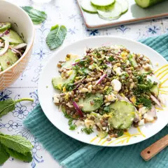 Salade de lentilles, concombre, oignon rouge et feta émiettée, garnie d'herbes fraîches. Un délice léger et savoureux.