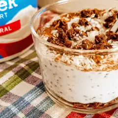 Yogurt greco naturale con semi di chia, cocco grattugiato e granola croccante. Un delizioso e salutare spuntino.