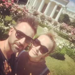 Mateusz Ziółko z żoną w słoneczny dzień wśród kwitnących róż.
