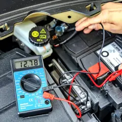 Pomiar napięcia akumulatora multimetrem. Sprawdzanie, ile trwa odsiarczanie akumulatora, to kluczowy etap diagnostyki.