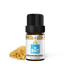 Butelka olejku eterycznego z kadzidłowcem (frankincense) obok żywicy. Elemi, czyli kadzidłowiec, to cenny składnik.