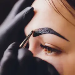 Stylist nakłada hennę na brwi. Zastanawiasz się, ile kosztuje henna?