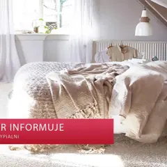 Miękka, jasna wykładzina dywanowa w sypialni tworzy przytulną atmosferę. Na łóżku leżą beżowe koce, a obok stoi drewniane krzesełko z jasnoniebieskim pledem.