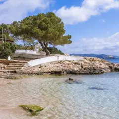 Piękna plaża na Ibizie, idealne miejsce, by zobaczyć błękitne morze i poczuć słońce. Na horyzoncie luksusowy jacht.