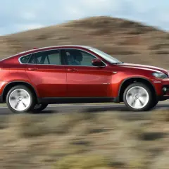 Czerwony BMW X6 pędzi po pustynnej drodze. Oto moto!