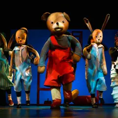 Pluszowe postacie na scenie, jak z repertuaru Teatru Arlekin. Miś, królik, słoń i klaun w kolorowych strojach.