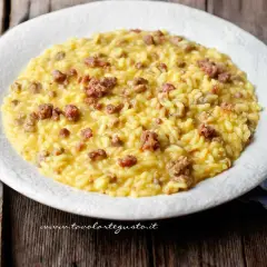 Un cremoso risotto con salsiccia, servito su un piatto bianco, pronto per essere gustato.