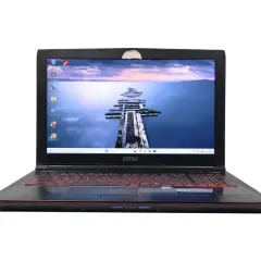 Czarny laptop MSI z podświetlaną na czerwono klawiaturą. Na ekranie widok na drewniane molo. Zastanawiasz się, jaki Windows do starego laptopa?