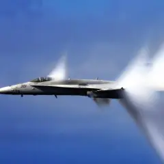 Myśliwiec F/A-18 Super Hornet przekracza barierę dźwięku, tworząc stożki kondensacji. Niesamowita prędkość samolotu w akcji.