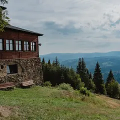 Drewniany schron na zboczu, skąd rozpościera się widok na Beskidy. Idealne miejsce na odpoczynek po wędrówce szlakami Wisły.