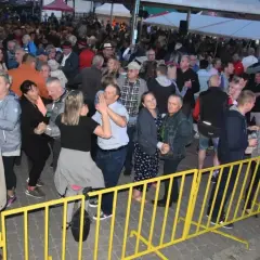 Tłum ludzi bawi się na ostrzyce koncert, tańcząc i świętując.
