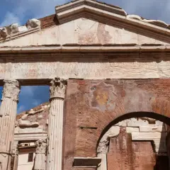 Antico portico d'Ottavia a Roma, con iscrizioni latine e resti di affreschi su mattoni antichi.