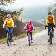 Rodzina na rowerach przemierza malowniczą dolinę Wisłoki jesienią.