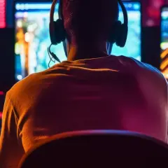 Gracz w słuchawkach przed wieloma monitorami, szukający darmowych gier na Steam.